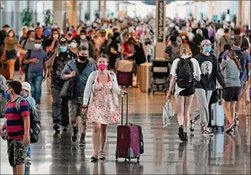  ?? Rick Bowmer / Associated Press ?? People walk through Salt Lake City Internatio­nal Airport in Salt Lake City on Thursday. This summer is already shaping up to be a difficult one for air travelers as airlines are struggling to keep up with the rising number of passengers.