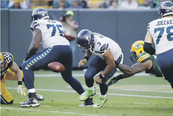  ?? JOE ROBBINS/GETTY IMAGES ?? Seattle Seahawks quarterbac­k Russell Wilson fumbles the football as he is hit by Green Bay Packers defensive lineman Mike Daniels in the third quarter on Sunday in Green Bay, Wis. Wilson’s offence couldn’t manage a touchdown as the Packers won 17-9.