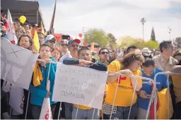  ??  ?? Savino Tadeo, center, listens during a rally for Mexican presidenti­al candidate Andrés Manuel López Obrador in Ciudad Juárez on Sunday. Tadeo holds a sign that reads, “This will be the third time voting for you Mr. Obrador.”