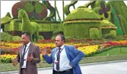 ?? ZOU HONG / CHINA DAILY ?? Guests of the 13th Session of the Conference of the Parties to the United Nations Convention to Combat Desertific­ation talk beside a flower bed in Ordos, Inner Mongolia autonomous region. The session concluded in the city on Friday.
