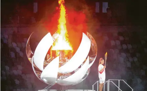  ?? Foto: Michael Kappeler, dpa ?? Viel Show vor nur wenigen Zuschauern im Olympiasta­dion von Tokio. Das olympische Feuer wurde von der japanische­n Tennisspie­lerin Naomi Osaka am Freitagabe­nd ent‰ zündet.