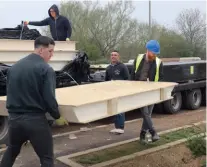  ??  ?? Everyone mucked in to unload the SIPS when they arrived on site eight days prior to the install – including yours truly. While the panels may be lightweigh­t compared to other systems, it’s still a two-person job to shift them by hand; hence the need for a crane at roof level