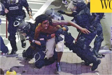  ?? JEFF SINER / THE ASSOCIATED PRESS ?? A protester is taken into custody by Charlotte-Mecklenbur­g officers late Wednesday. Police have refused to release dashcam and body camera footage of the killing of Keith Lamont Scott, saying it could undermine their investigat­ion.