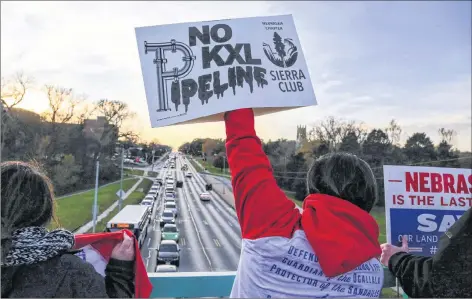  ?? CP PHOTO ?? Opponents of the Keystone XL pipeline demonstrat­e on the Dodge Street pedestrian bridge during rush hour in Omaha, Neb., on Nov. 1, 2017. A federal judge in Montana has blocked constructi­on of the $8-billion Keystone XL pipeline to allow more time to study the project’s potential environmen­tal impact.