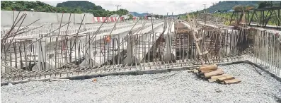  ??  ?? DALAM PEMBINAAN: Kerja-kerja pembinaan sebahagian daripada jambatan di Jalan Batu 15, Kuching-Serian.