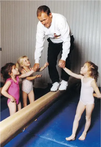  ?? FILES ?? Paul Rose hops on the balance beam in 1992 with the help of young gymnasts Aly Moses, left, Elise Poupart and Jamie Geni. Rose, who founded Rose City Gymnastics in 1970, died Tuesday at the age of 80.