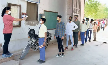  ??  ?? TEMPERATUR­E SCANNING before the Rajasthan Board Class 10 examinatio­ns, in Bikaner on June 30.