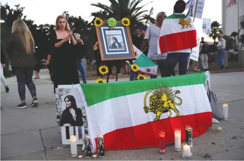  ?? (Bing Guan/Reuters) ?? IMAGES OF Mahsa Amini are displayed at a candleligh­t vigil outside the Wilshire Federal Building in Los Angeles last month, amid protests in many countries.