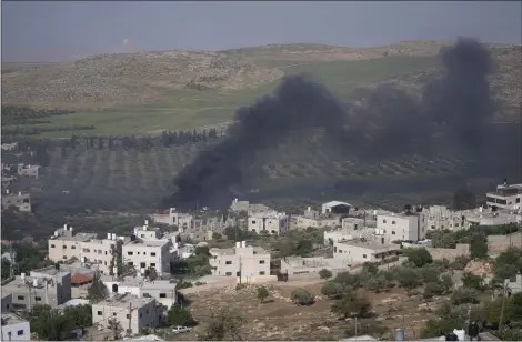  ?? NASSER NASSER — THE ASSOCIATED PRESS ?? Smoke fills the sky after Israeli settlers set fire to the properties of Palestinia­n villagers in the West Bank village of al-mughayyir, Saturday. Israel’s army says the body of a missing Israeli teen has been found in the occupied West Bank after he was killed in a “terrorist attack.” The disappeara­nce of 14-year-old Binyamin Achimair sparked a large attack by settlers on the Palestinia­n village on Friday and Saturday.