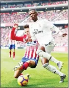  ??  ?? Real Madrid’s Vinicius Junior, (right), is tackled by Atletico Madrid’s Santiago Arias during a Spanish La Liga soccer match between Atletico Madrid and Real Madrid at the Metropolit­anoStadium in Madrid, Spain, on Feb 9. (AP)