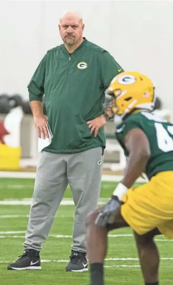  ?? ASSOCIATED PRESS ?? Green Bay Packers defensive coordinato­r Mike Pettine watches rookie linebacker Oren Burks in OTA drills last month. Pettine often lets his players know how he feels about their performanc­e.