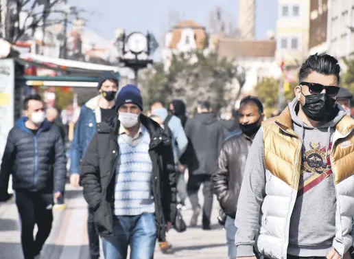  ??  ?? People wearing protective masks walk on a street in Edirne, northweste­rn Turkey, Feb. 25, 2021.