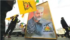  ?? (Thaier al-Sudani/Reuters) ?? IRAQI MILITIA members hold the picture of the Qassem Soleimani, who was killed by a US strike, in January. Ex-CENTCOM chief Joseph Votel said the strike ‘caused Iran to certainly be more cautious about how the US will respond.’