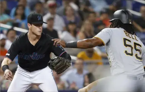  ?? Associated Press photos ?? Marlins third baseman Brian Anderson prepares to tag out the Pirates’ Josh Bell, who was trying to advance from second on a grounder by Colin Moran in the fourth inning.