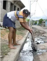  ??  ?? Una vecina del barrio Moscú saca lodo de su vivienda.