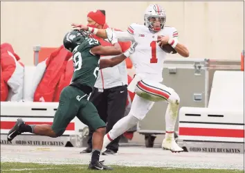  ?? Gregory Shamus / Getty Images ?? Ohio State’s Justin Fields tries to get past the tackle of Michigan State’s Shakur Brown on Dec. 5.