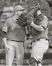  ?? Jay C. Hong / Associated Press ?? Righthande­r Collin McHugh, left, chats with catcher Evan Gattis during Friday’s game. It was Gattis’ first game back since missing 19 with a concussion.