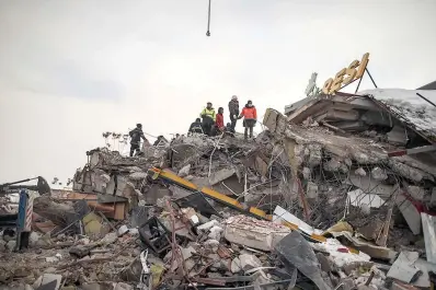  ?? (AP Photo/Emrah Gurel) ?? Rescue workers search for survivors Tuesday on a collapsed building in Malatya, Turkey. Search teams and aid are pouring into Turkey and Syria as rescuers working in freezing temperatur­es dig through the remains of buildings flattened by a magnitude 7.8 earthquake.