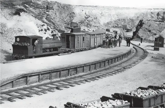  ??  ?? With the day’s labour complete at Stirling Hill quarry, prisoners join their train for the return journey to the prison yard – Edward VII simmers at the head of the train. The quarry face, crane and an array of sidings are in the background, and two rakes of loaded tippler wagons are in view, one of these in the foreground. They carry granite for crushing and for using in the manufactur­e of concrete blocks at the work yard near the prison. Flat-bottom rail is in use, spiked to sleepers and, on the line skirting the nearside of the platform, unusually there is a check-rail of sorts on the inside of the curve, whereas the outside rail is shored up too, which suggests that the rails have spread at some time. The platform is wooden-faced and then in-filled. The leading vehicle in the train is the brake van, which was also used by any civilians travelling on the line, followed by the carriages for the inmates. After dismantlin­g of the railway, the carriage bodies found further use on local farms as stores or animal shelters. GNSRA Collection