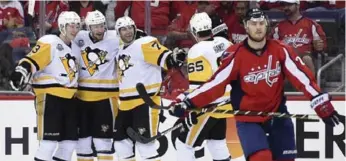  ?? NICK WASS/THE ASSOCIATED PRESS ?? Penguins teammates celebrate Matt Cullen’s second-period goal behind Kevin Shattenkir­k of the Capitals.