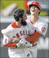  ?? The Associated Press ?? Ashley Landis
Shohei Ohtani, right, and Anthony Rendon celebrate after rallying the Angels past the Nationals on Sunday.