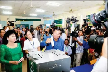  ?? HENG CHIVOAN ?? Prime Minister Hun Sen (right), with his wife Bun Rany (left), votes in Kandal last Sunday.