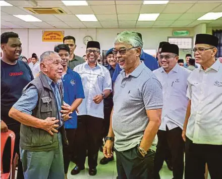  ?? (Foto Ahmad Ukasyah/bh) ?? Sultan Pahang Al-sultan Abdullah Ri’ayatuddin Al-mustafa Billah Shah beramah mesra bersama penduduk ketika mencemar duli melawat dan mengurniak­an sumbangan kepada mangsa banjir di pusat pemindahan sementara (PPS) di Sekolah Menengah Kebangsaan (SMK) Karak Setia, Karak, semalam.