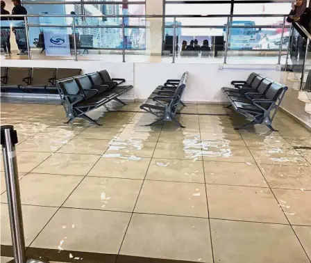  ??  ?? Departure deluge: The flooded departure lounge at Penang Internatio­nal Airport following a downpour.