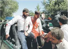  ?? — Reuters photo ?? Injured men arriving at a hospital.