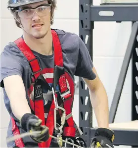  ?? DAVID ROSSITER, THE CANADIAN PRESS ?? Student Ryan Hanna works with safety equipment during a class at the Lethbridge College wind turbine technician program.