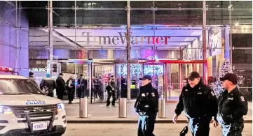  ??  ?? NYPD officers stand near the Time Warner Centre Building after the building was evacuated due to a bomb threat. — Reuters photo