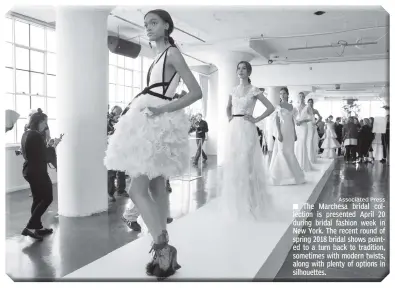  ?? Associated Press ?? The Marchesa bridal collection is presented April 20 during bridal fashion week in New York. The recent round of spring 2018 bridal shows pointed to a turn back to tradition, sometimes with modern twists, along with plenty of options in silhouette­s.