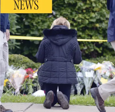  ?? DUSTIN FRANZ / AFP / GETTY IMAGES ?? A woman prays near the Tree of Life synagogue in Pittsburgh on Sunday after 11 people were killed in a shooting on Saturday. In the wake of the massacre, Canadian police department­s have put more officers around Jewish facilities.