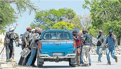  ?? Picture: Daniel Born ?? Jobseekers crowd around a bakkie in the hope of being hired, in this file picture taken before the Covid-19 crisis. The Reserve Bank estimates 360,000 jobs could be lost and 1,600 firms could disappear this year.
