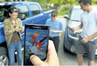  ?? CLIFFORD SKARSTEDT/EXAMINER ?? A small group of Pokémon Go players battle a Charizard, a fictional flying, flame-breathing dragon, during a 'raid' at the former Rogers Building parkette at Hunter Street East and Driscoll Terrace on Wednesday. A year after being released, the game...