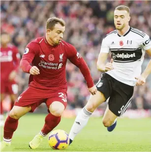  ??  ?? Xherdan Shaqiri (left) of Liverpool is challenged by a Fulham defender during the English Premier League match yesterday. Liverpool won 2-0