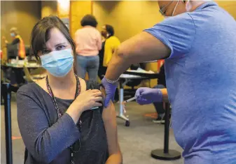  ?? Jessica Christian / The Chronicle ?? Efren Bose, UC Berkeley University Health Services pharmacy director, administer­s the first dose of Moderna vaccine to UHS Medical Director Anne Harte at Tang Center on Jan. 14.