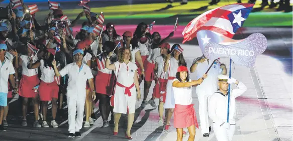  ?? Andre kang / enviado especial ?? Arriba, la nadadora Vanessa García carga la bandera de Puerto Rico durante el desfile de la delegación en los Juegos en Barranquil­la.