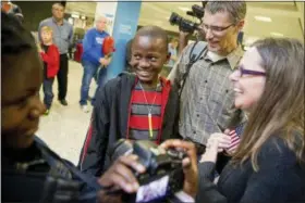  ?? ANDREW HARNIK — ASSOCIATED PRESS ?? In a 2015 photo, Jennifer and Eric Sands of Illinois, right, accompanie­d by their adopted daughter Joy, 12, left, smile as their adopted son Issaac, 12, center, arrives from the Congo at Dulles Internatio­nal Airport in Dulles, Va.