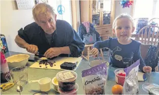  ??  ?? Team work at its finest. Lila and Papa (Jim Wells) were hard at work preparing the fruit and nuts so that Nanny could bake the fruit cake.