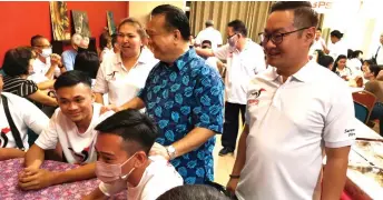  ?? ?? Nanta (standing, second right) and Tiang, on his left, interact with the Chinese youths at the event in Kapit.