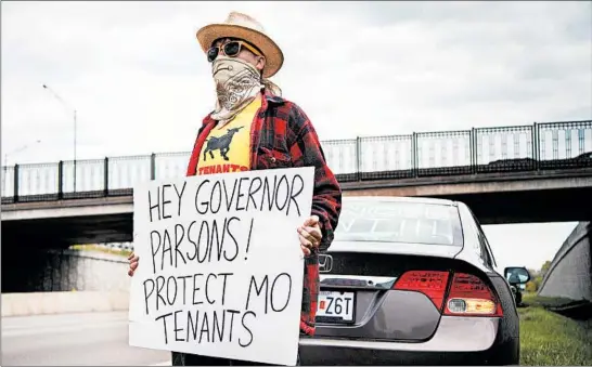  ?? CHRISTOPHE­R SMITH/THE NEW YORK TIMES ?? Emma Witbolsfeu­gen stands on the shoulder of I-70 last month in Independen­ce, Missouri, to demonstrat­e for rent forgivenes­s as the coronaviru­s crisis continues.