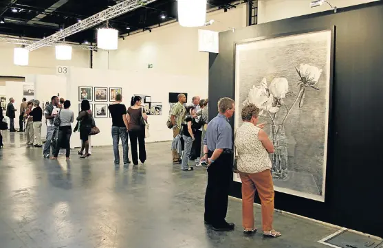  ?? /Sean O' Toole ?? Social setting: Visitors at the 2009 Joburg Art Fair appraise William Kentridge’s untitled charcoal drawing. Over the past 10 years, the fair has more than doubled the number of participat­ing galleries.