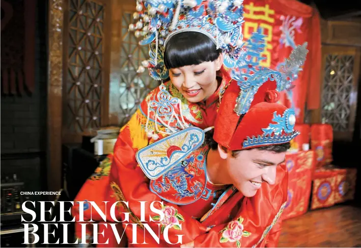  ??  ?? American groom Bryan Shapiro carries his bride Wana Zhang during their traditiona­l Chinese wedding ceremony in a restaurant on Huixin North street near the China Daily office in Beijing.