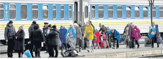  ?? CAROL GUZY / ZUMA PRESS ?? Un hombre yace muerto en el andén de la estación de Leópolis mientras otros intentan escapar de la guerra.