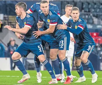  ??  ?? Aberdeen’s Andy Considine, centre, and Scotland team-mates in the Slovakia game.