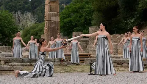  ?? ?? Actors light a torch at the o  cial   ame lighting for the Paris Olympics at the home of the ancient games in Greece.