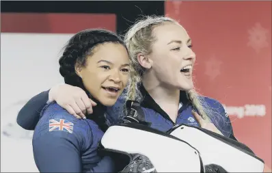  ??  ?? Driver Mica McNeill and Mica Moore of Britain smile after their final heat in the women’s two-man bobsled final.