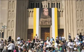  ?? Brendan Smialowski / AFP / Getty Images ?? People wait for the arrival of Pope Francis for the canonizati­on of Junipero Serra, attended by 30,000 outside the Basilica of the National Shrine of the Immaculate Conception.