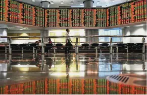  ?? By INTAN FARHANA ZAINUL ?? Foreign selling: Investors monitoring stock prices at a brokerage in Kuala Lumpur. Foreign investors were net sellers on Bursa yesterday.